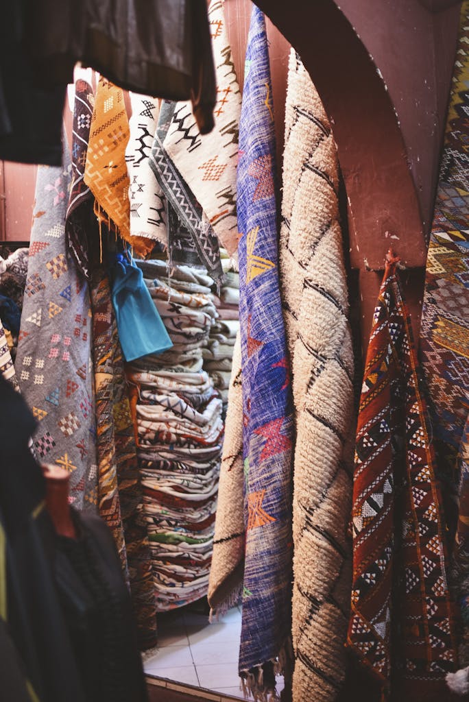 Colorful Moroccan rugs displayed in a market in Agadir, showcasing traditional patterns and textures.