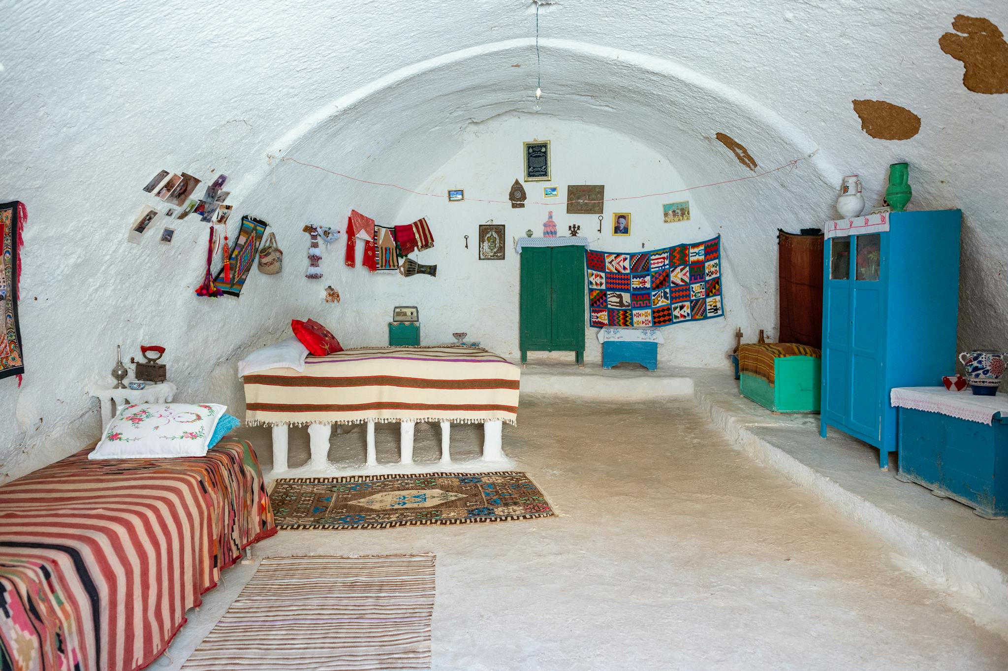 Cozy cave interior showcasing traditional Berber decor and vibrant textiles.