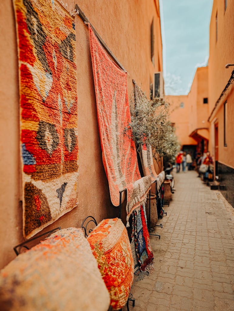 Explore a lively Moroccan alley adorned with vibrant carpets in Marrakesh.