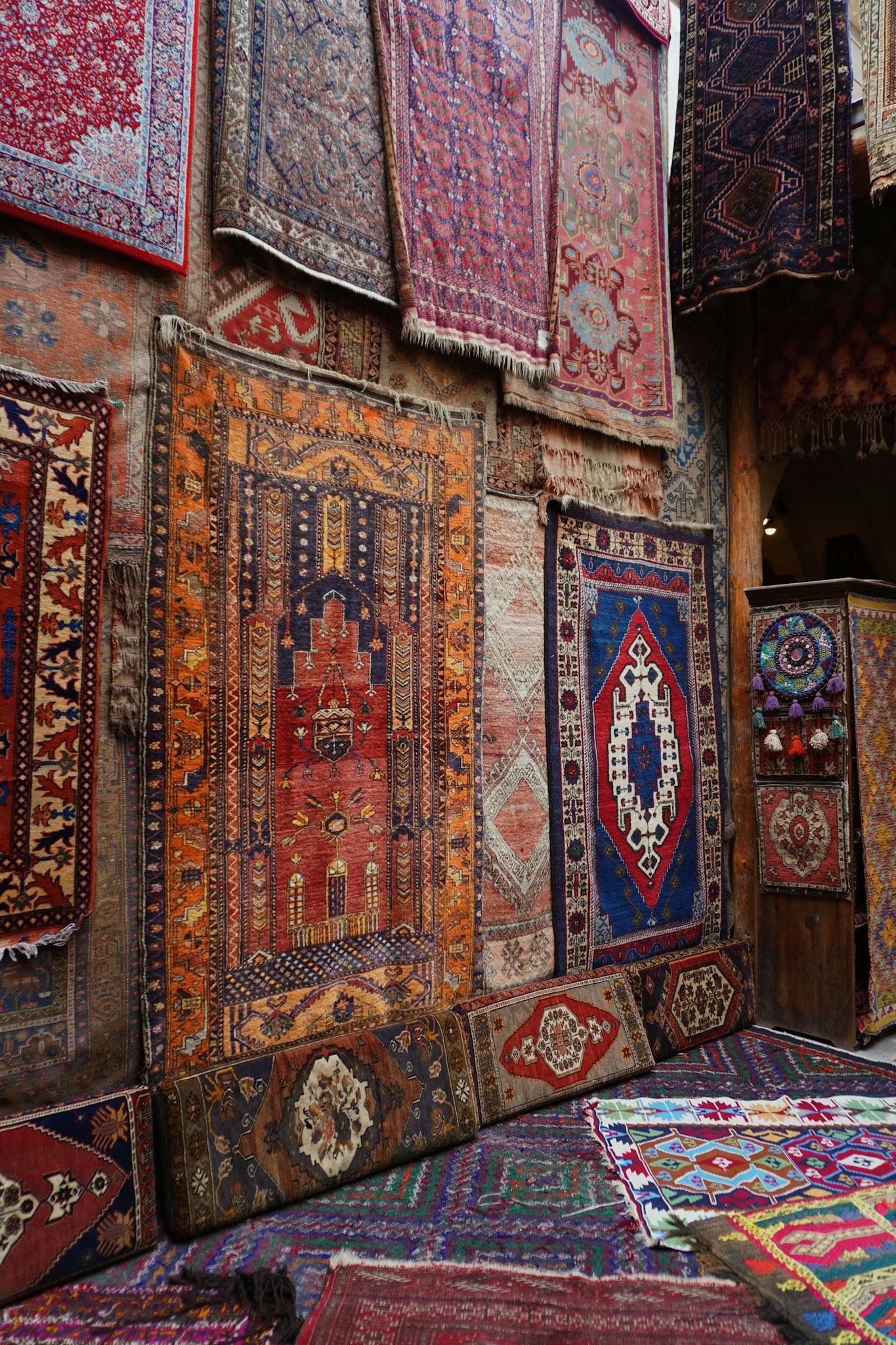 Vibrant display of traditional rugs in an antique market showcasing intricate patterns and designs.