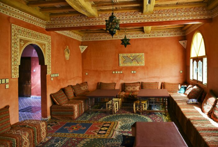 Vibrant Moroccan interior with traditional decor, patterns, and cozy seating in a sunlit living room.
